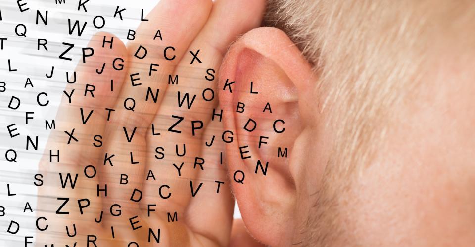 En människa som försöker höra med en hand på örat. 