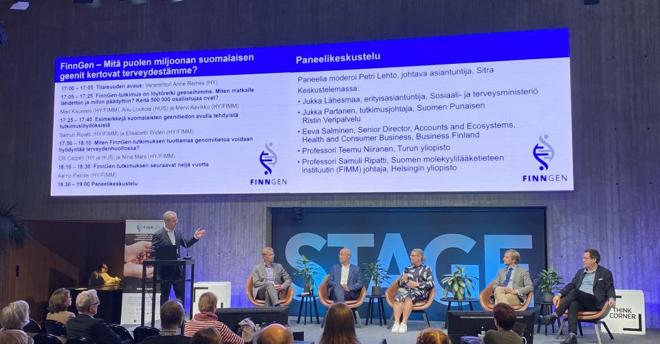 Paneldebatten börjar, på scenen finns moderatorn och fem panelister, i bakgrunden finns Tiedekulman STAGE-text och programbild.