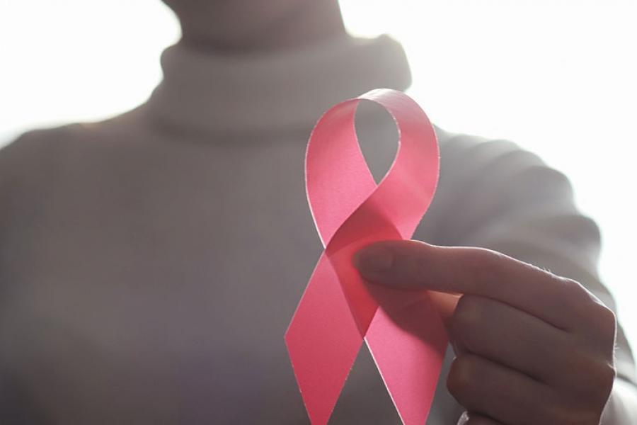 Woman holding a reb ribbon in her hand.