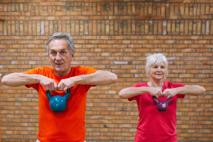 A woman and a man doing a kettlebell workout. 