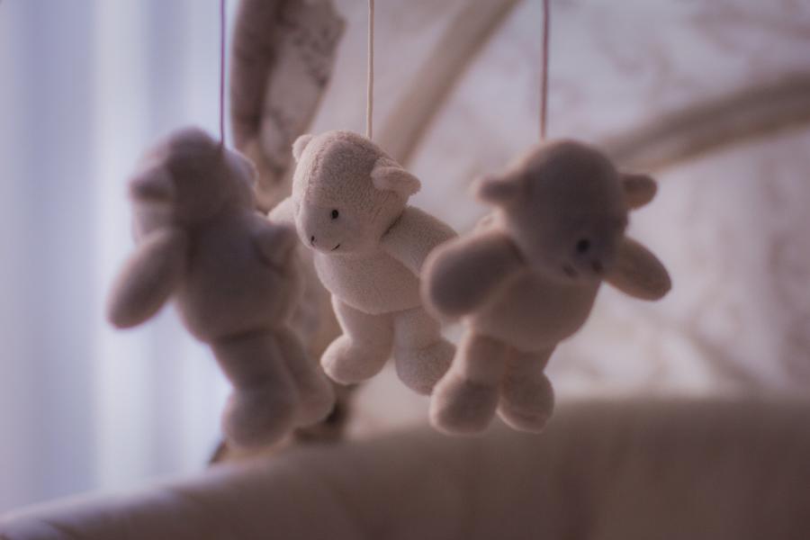 Mobile toy for babies with three soft toys hanging from it.