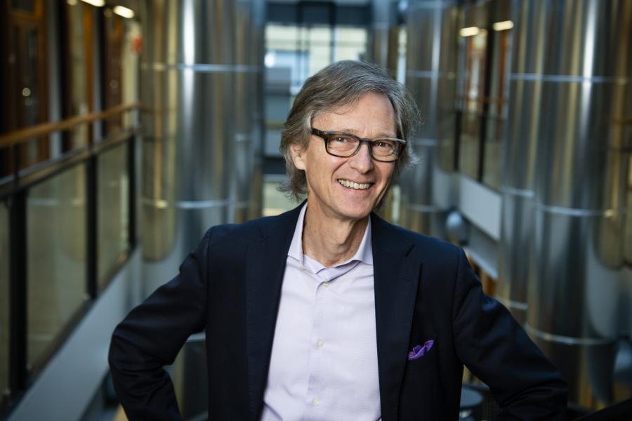 Hymyilevä Aarno Palotie seisomassa portaikossa.